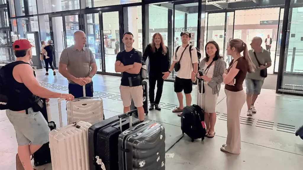 Grupa ljudi s prtljagom na aerodromu ili stanici