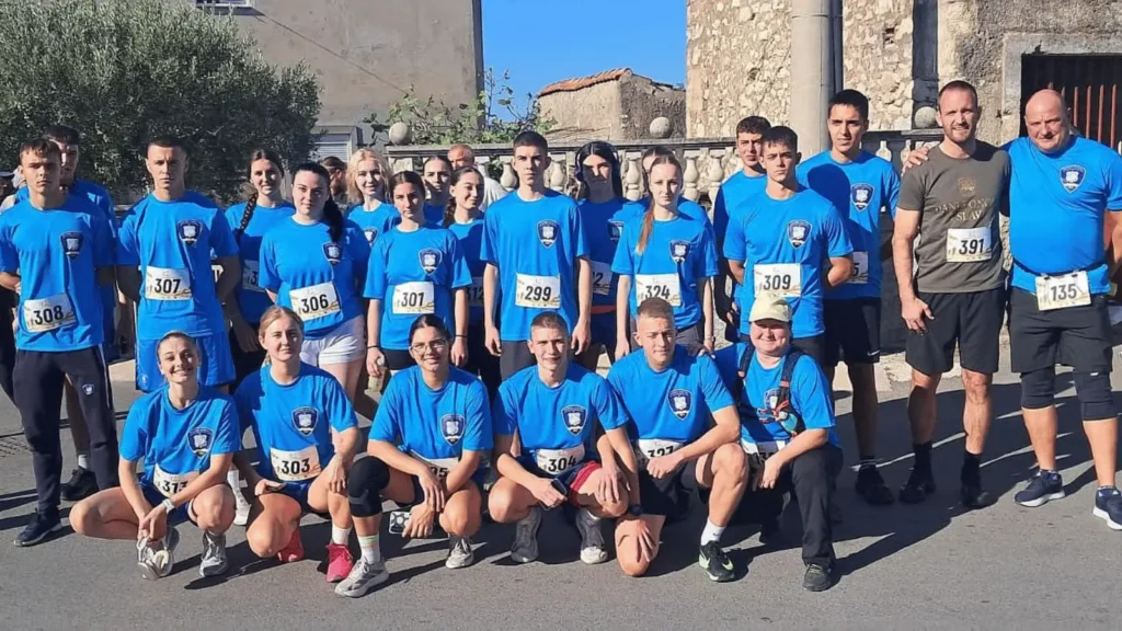 Skupina ljudi u plavim majicama i s natjecateljskim brojevima
